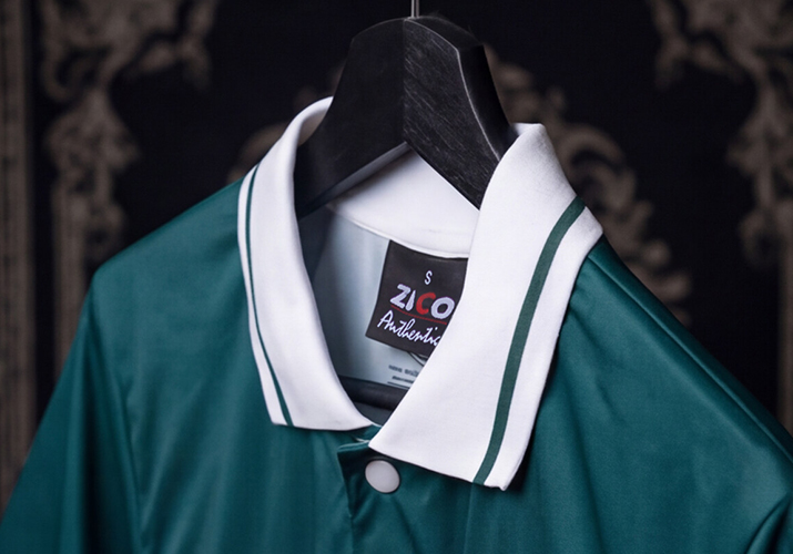 Detalles de confección de camiseta Montdebó | Fernando Alonso Fotografía de detalle del cuello blanco con ribete verde y etiqueta Zico de una camiseta Montdebó inspirada en Fernando Alonso.