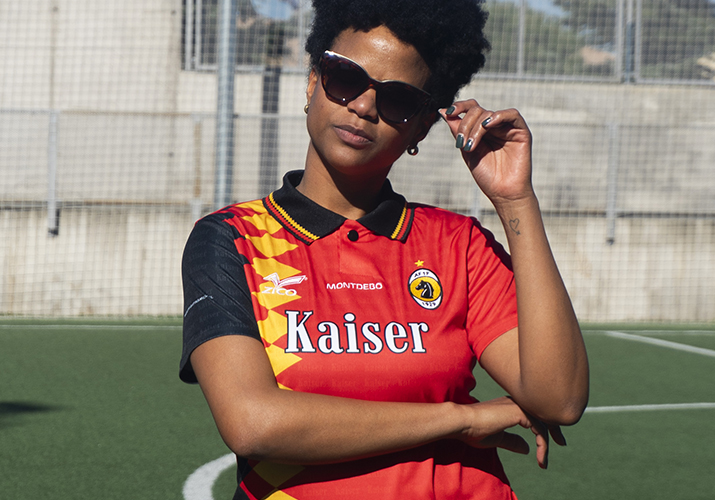 Fotografía de moda Montdebó | Colección Michael Schumacher Modelo femenina con gafas de sol y camiseta deportiva roja y negra de Montdebó inspirada en Michael Schumacher.