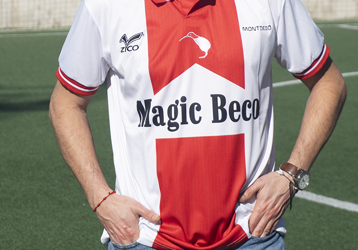 Fotografía de moda deportiva Montdebó | Colección Ayrton Senna Modelo masculino con camiseta roja y blanca de Montdebó inspirada en Ayrton Senna, fotografiado en un campo de fútbol.